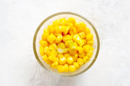 Foto de Granos amarillos de maíz en un bol sobre fondo blanco - Imagen libre de derechos
