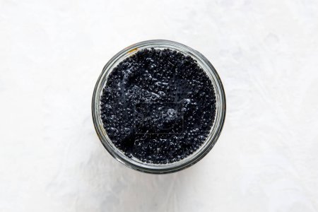 Téléchargez les photos : Caviar noir en pot de verre sur fond blanc - en image libre de droit