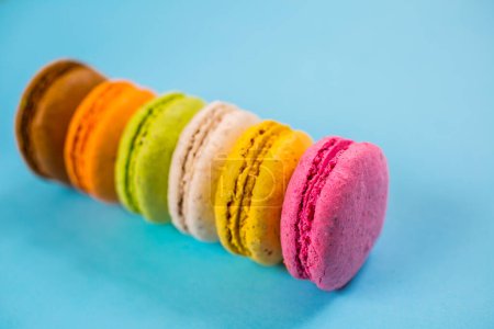 Foto de Pastel de macarrones o macarrones sobre fondo azul desde arriba, coloridas galletas de almendras, colores pastel - Imagen libre de derechos
