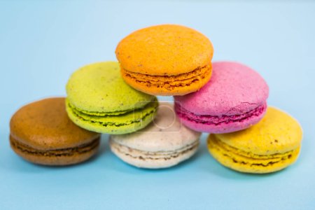 Téléchargez les photos : Gâteau macarons ou macarons sur fond bleu d'en haut, biscuits aux amandes colorées, couleurs pastel - en image libre de droit
