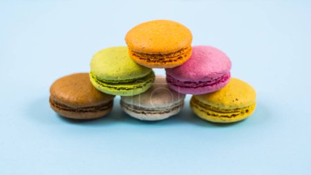 Téléchargez les photos : Gâteau macarons ou macarons sur fond bleu d'en haut, biscuits aux amandes colorées, couleurs pastel - en image libre de droit