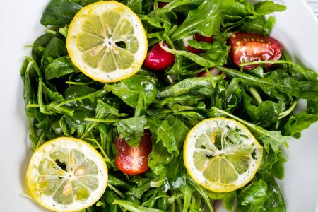 Téléchargez les photos : Salade de tomates vertes avec roquette et citron - en image libre de droit