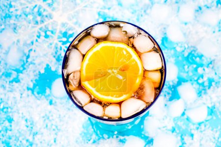 Téléchargez les photos : Boisson d'été avec glace et citron sur fond bleu - en image libre de droit