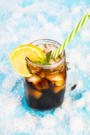 Foto de Bebida de verano con hielo y limón sobre fondo azul - Imagen libre de derechos