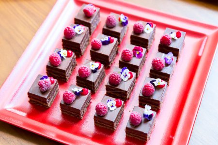 Téléchargez les photos : Petits gâteaux au chocolat aux framboises et fleurs comestibles - en image libre de droit