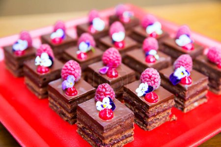 Téléchargez les photos : Petits gâteaux au chocolat aux framboises et fleurs comestibles - en image libre de droit