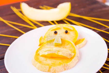 Téléchargez les photos : Alimentation saine et amusante pour les enfants, singe melon - en image libre de droit