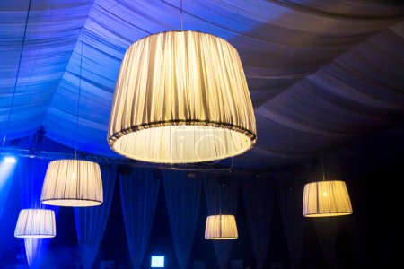 Photo for Illuminated modern chandeliers on ceiling - Royalty Free Image