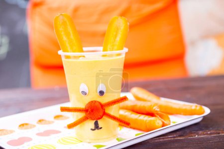 Photo for Childish carrot smoothie in cup - Royalty Free Image