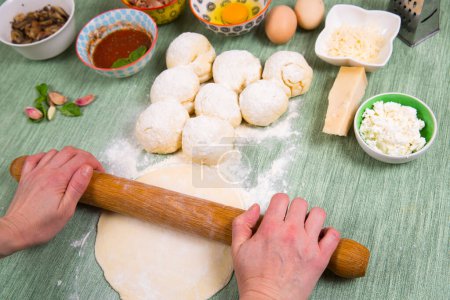 Photo for Baker prepares the dough on a table, female hands knead the paste with flour, homemade pastry for bread or pizza, top view, rustic style - Royalty Free Image