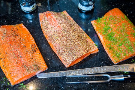 Foto de Un delicioso salmón fresco con pimienta, especias y caviar sobre un fondo negro - Imagen libre de derechos