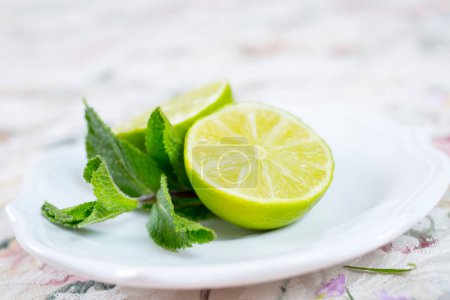 Photo for Lime and mint on white plate - Royalty Free Image