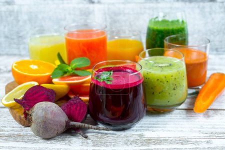 Photo for Fresh detox juices from fruits and vegetables in glass bottles on a wooden background - Royalty Free Image