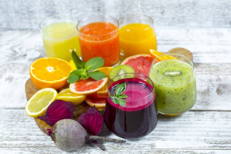 Téléchargez les photos : Jus de désintoxication frais de fruits et légumes dans des bouteilles en verre sur fond de bois - en image libre de droit