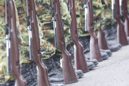 Foto de Soldados en fila. Pistola en mano. Ejército, Botas Militares líneas de comandos soldados en uniformes de camuflaje - Imagen libre de derechos