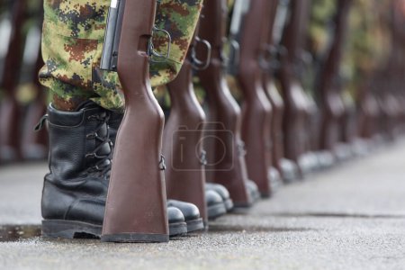 Photo for Soldiers stand in row. Gun in hand. Army, Military Boots lines of commando soldiers in camouflage uniforms - Royalty Free Image