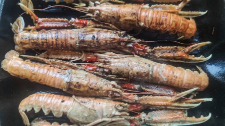 Téléchargez les photos : Crevettes cuites au four dans une poêle noire - en image libre de droit
