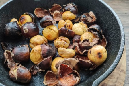 Photo for Roasted chestnuts in a grated pan - Royalty Free Image