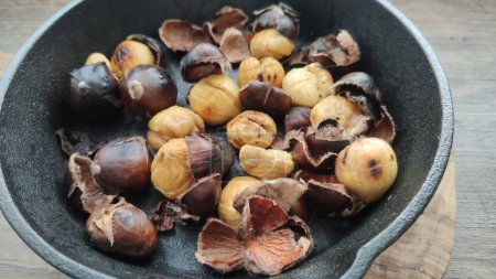Photo for Roasted chestnuts in a grated pan - Royalty Free Image