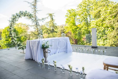 Téléchargez les photos : Une belle cérémonie de mariage avec des fleurs sur la terrasse au coucher du soleil - en image libre de droit