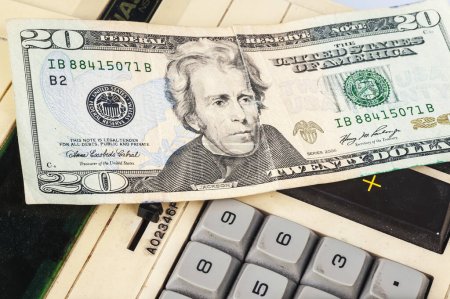 Foto de Dólares estadounidenses y calculadora sobre fondo blanco - Imagen libre de derechos