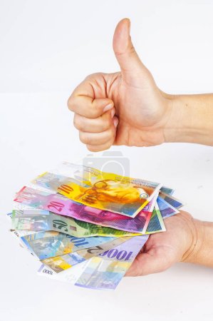 Téléchargez les photos : Billets de banque à main femelle Franc suisse et main femelle montrant pouce vers le haut signe contre - en image libre de droit