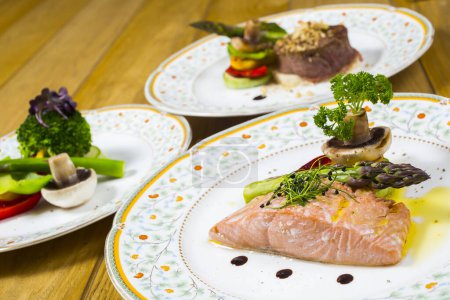 Foto de Filete de salmón con verduras y filetes en platos - Imagen libre de derechos