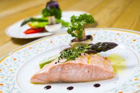 Foto de Filete de salmón con verduras y filetes en platos - Imagen libre de derechos