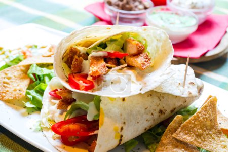 Téléchargez les photos : Tortilla mexicaine enveloppée de poitrine de poulet et de légumes - en image libre de droit