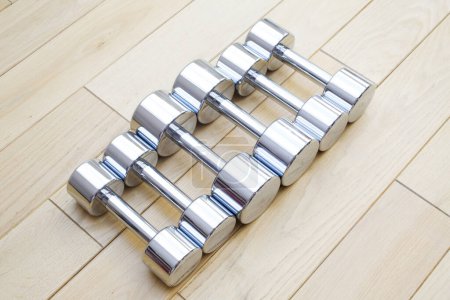 Photo for Silver dumbbells on wooden background - Royalty Free Image