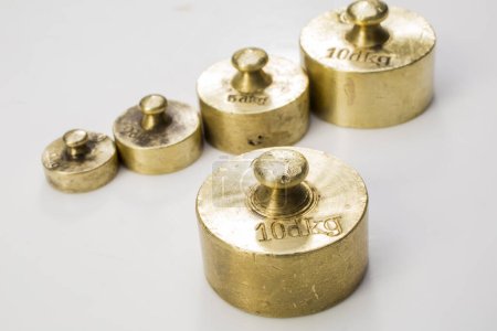 Photo for Collection of Thee Vintage Golden And Silver Calibration Weights on White Background - Royalty Free Image