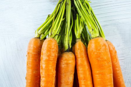 Photo for Stack of carrots on a white wooden background - Royalty Free Image