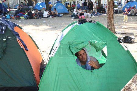 Téléchargez les photos : SERBIE, BELGRADE - 01 septembre 2015 : Le parc de la gare des migrants syriens est devenu une petite ville. Certains ont même installé des tentes et dans lesquelles ils résident, tandis que la plupart dorment sous le ciel ouvert
. - en image libre de droit