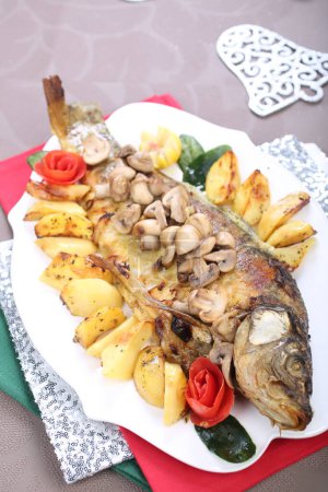 Foto de Carpa asada de pescado con patatas y setas - Imagen libre de derechos