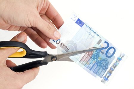 Photo for Hands cutting one banknote with scissors - Royalty Free Image