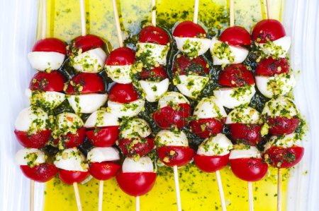 Foto de Queso mozzarella, tomates cherry, hojas de albahaca y aceite de oliva - ingredientes de ensalada caprese - Imagen libre de derechos
