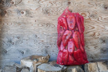 Foto de Pimientos rojos en un saco sobre fondo de madera - Imagen libre de derechos