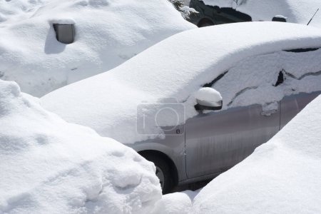 Foto de Vehículos cubiertos de nieve en la ventisca invernal en el estacionamiento - Imagen libre de derechos