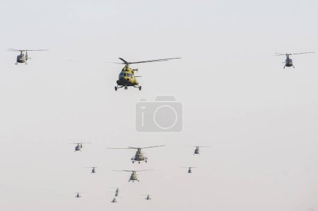 Photo for A group of military helicopters flying on the background of blue sky - Royalty Free Image