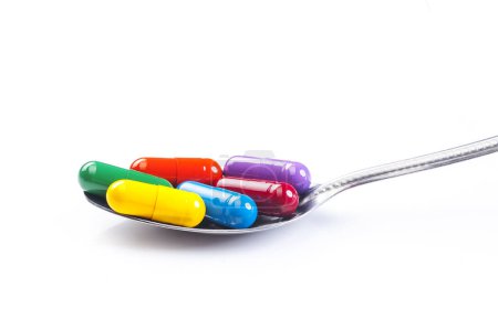 Photo for Spoon full of various pills on white background - Royalty Free Image