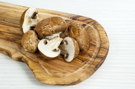 Photo for A pile of raw exotic mushrooms on a wooden plate - Royalty Free Image