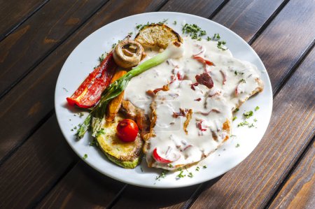 Téléchargez les photos : Poitrine de poulet rôtie avec crème sure et légumes servis sur la table - en image libre de droit
