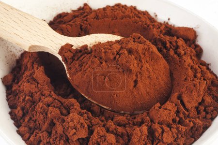 Photo for Heap of cocoa powder with wooden scoop isolated on the white background - Royalty Free Image