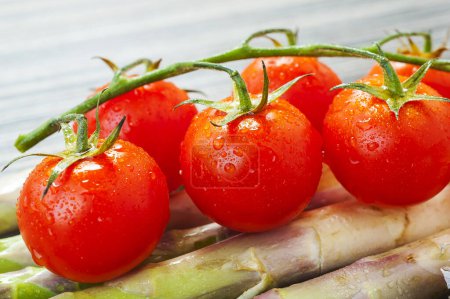 Téléchargez les photos : Tomates cerises sur une surface en bois avec lumière naturelle - en image libre de droit