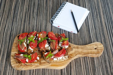 Foto de Crostini con anchoas, aceitunas y tomates - Imagen libre de derechos