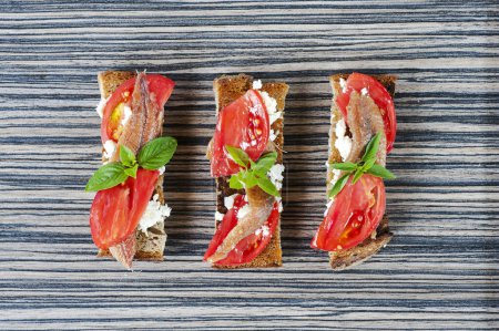 Photo for Crostini with anchovies, olives and tomatoes - Royalty Free Image