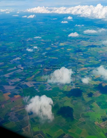Téléchargez les photos : Vue aérienne du paysage de champs verts avec paysage nuageux depuis la fenêtre de l'avion. Concept de voyage - en image libre de droit
