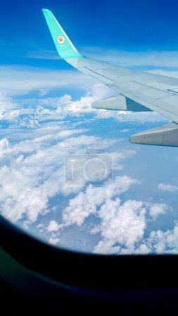 Téléchargez les photos : CHIANG MAI - THAÏLANDE. 7 octobre 2023 : Vue panoramique d'un beau ciel bleu clair avec des nuages duveteux à travers la fenêtre d'un vol de Nok Air. CNX-DMK. Concept de voyage - en image libre de droit