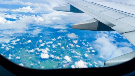 Téléchargez les photos : Vue aérienne d'un paysage nuageux pittoresque avec un ciel bleu depuis un avion - en image libre de droit