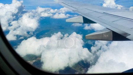 Téléchargez les photos : Vue aérienne du ciel et des nuages à travers une fenêtre d'avion. Concept de voyage. voyageur, voyage, vacances, tourisme, paysage, dynamique, nature, paysage, arrière-plan - en image libre de droit
